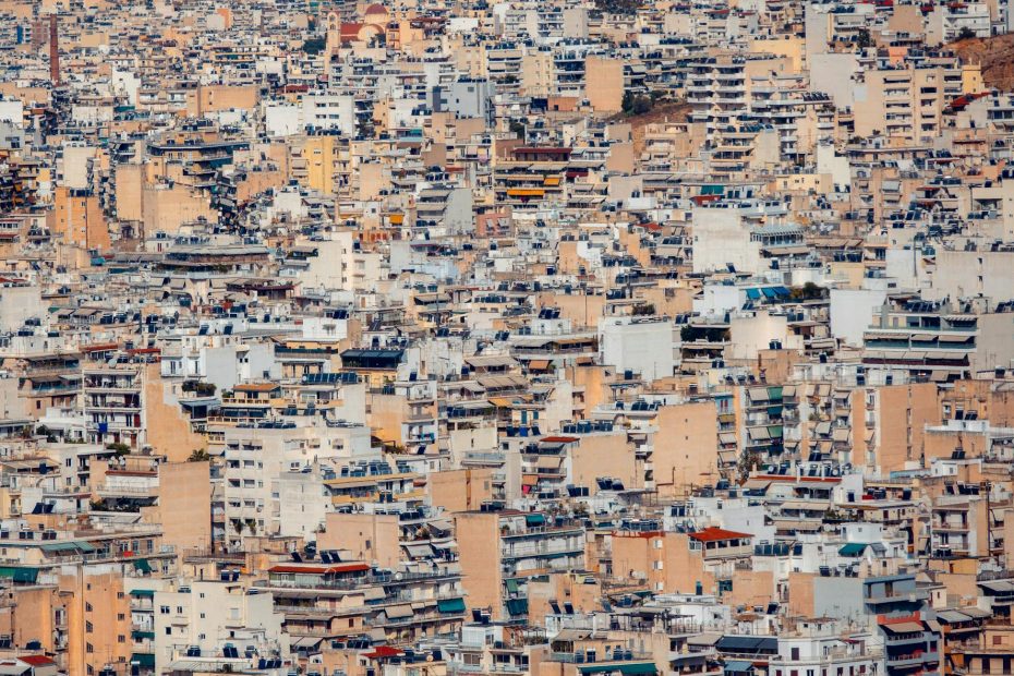Expansive view of densely packed rooftops and buildings in Athens, Greece showcasing urban architecture.