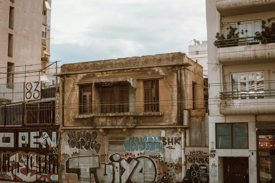 Old abandoned building in downtown Athens covered with graffiti, depicting urban decay.