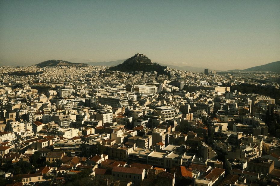 A stunning aerial view of Athens cityscape showcasing Mount Lycabettus at sunset.